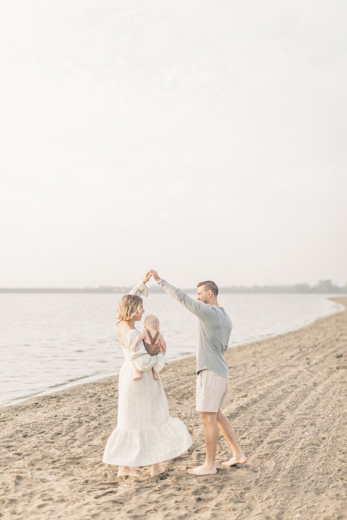 A mother holds her baby boy while her husband spins them around as they dance on the shore of a Kansas City lake. 