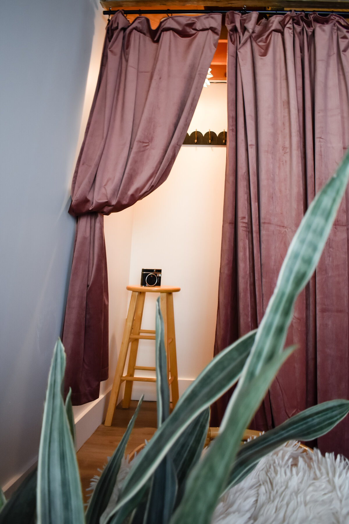 A blush curtain is pulled back to reveal a small dressing room