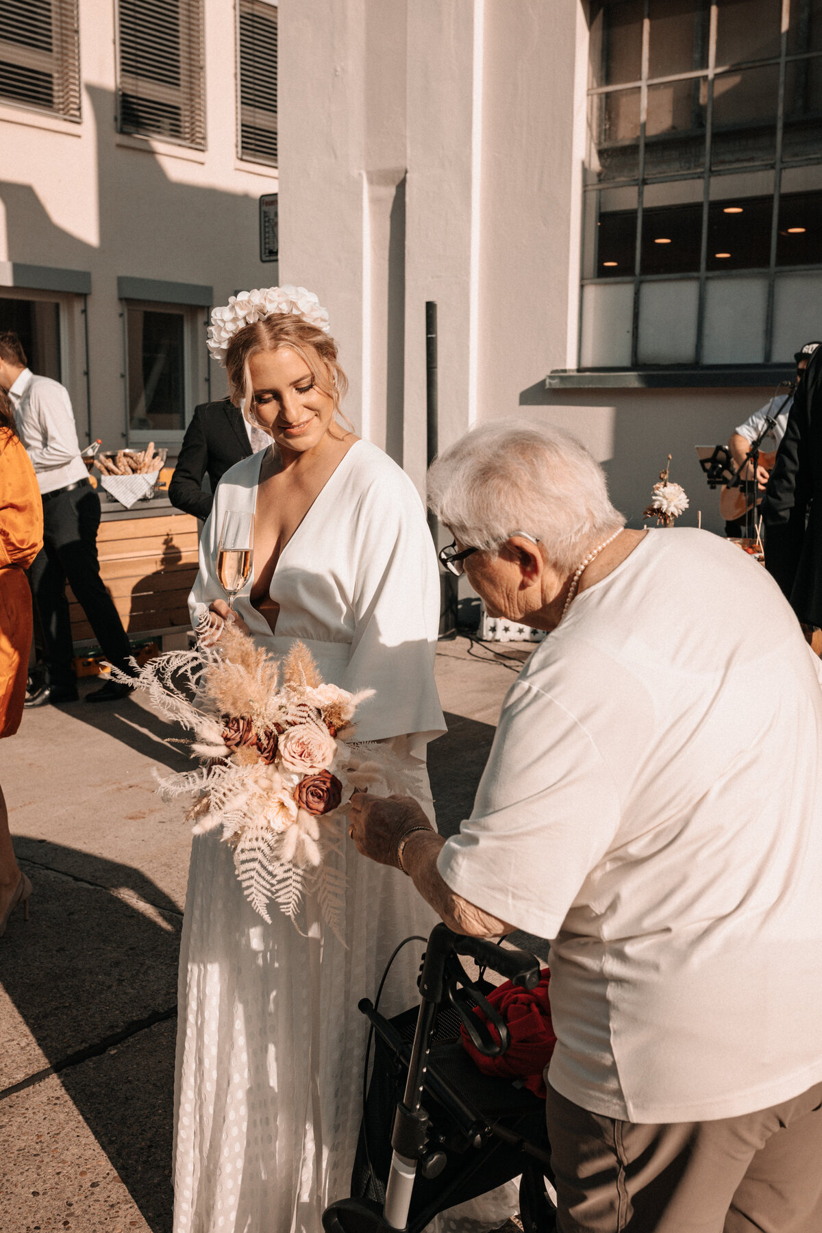 Braut im Sonnenlicht mit älterer Frau