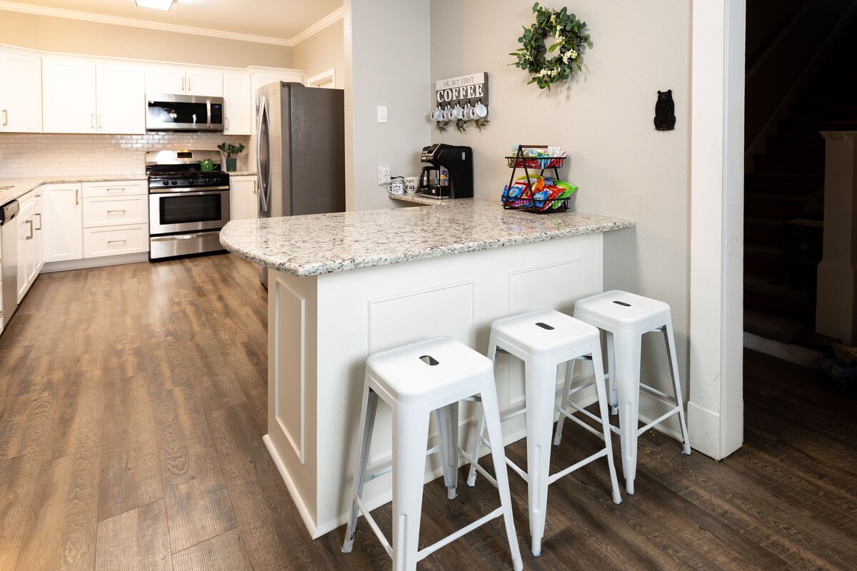 Fully stocked kitchen with countertop seating in this five-bedroom, 4-bathroom pet-friendly vacation rental house for 12 guests with free wifi, free parking, hot tub, mother-in-law suite, King beds and updated kitchen in downtown Waco, TX.
