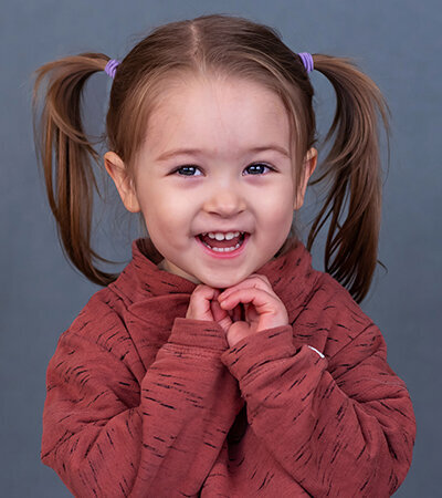Preschool girl smiling for her professional school photos in Vancouver
