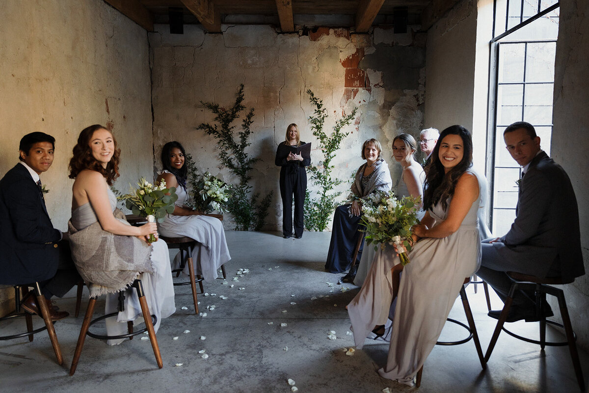 small number of guests seated and turned as they wait for the groom to walk down the aisle