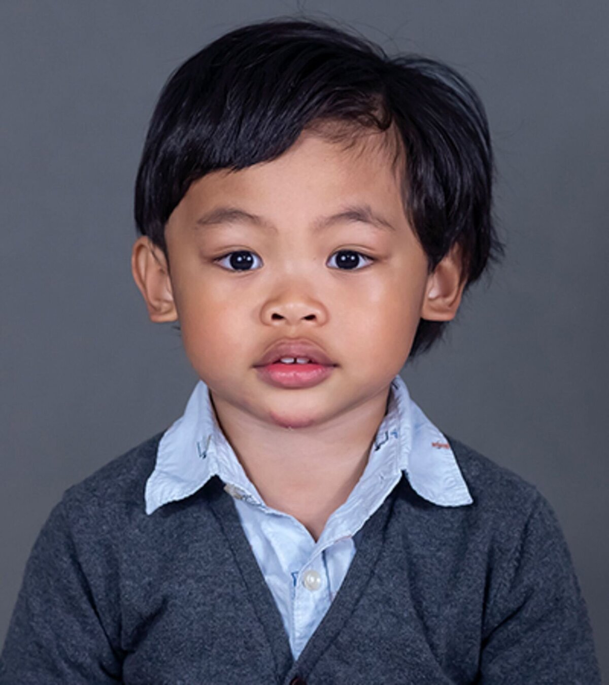 Child’s school portrait on grey background, captured by Tri-Cities photographer Amy Williams