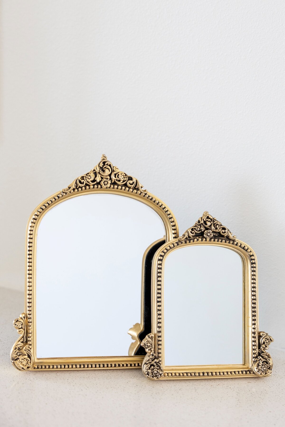 5x7 and 8x10 gold mirrors with ornate decor on the top