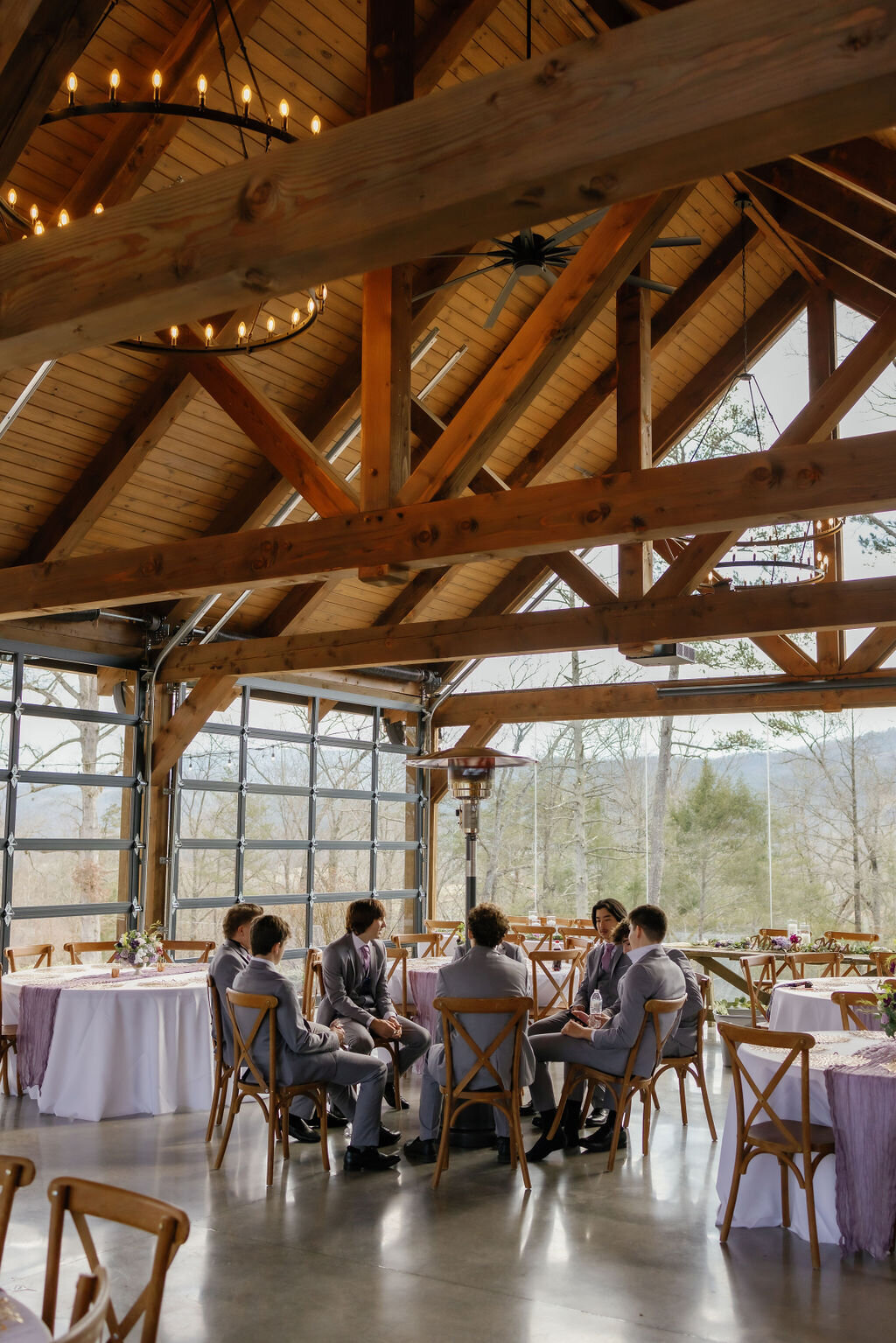 while eloping to Gatlinburg groom sits in a reception hall with his groomsmen for a prayer before the ceremony