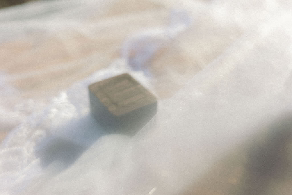 A wooden box with a veil over it.