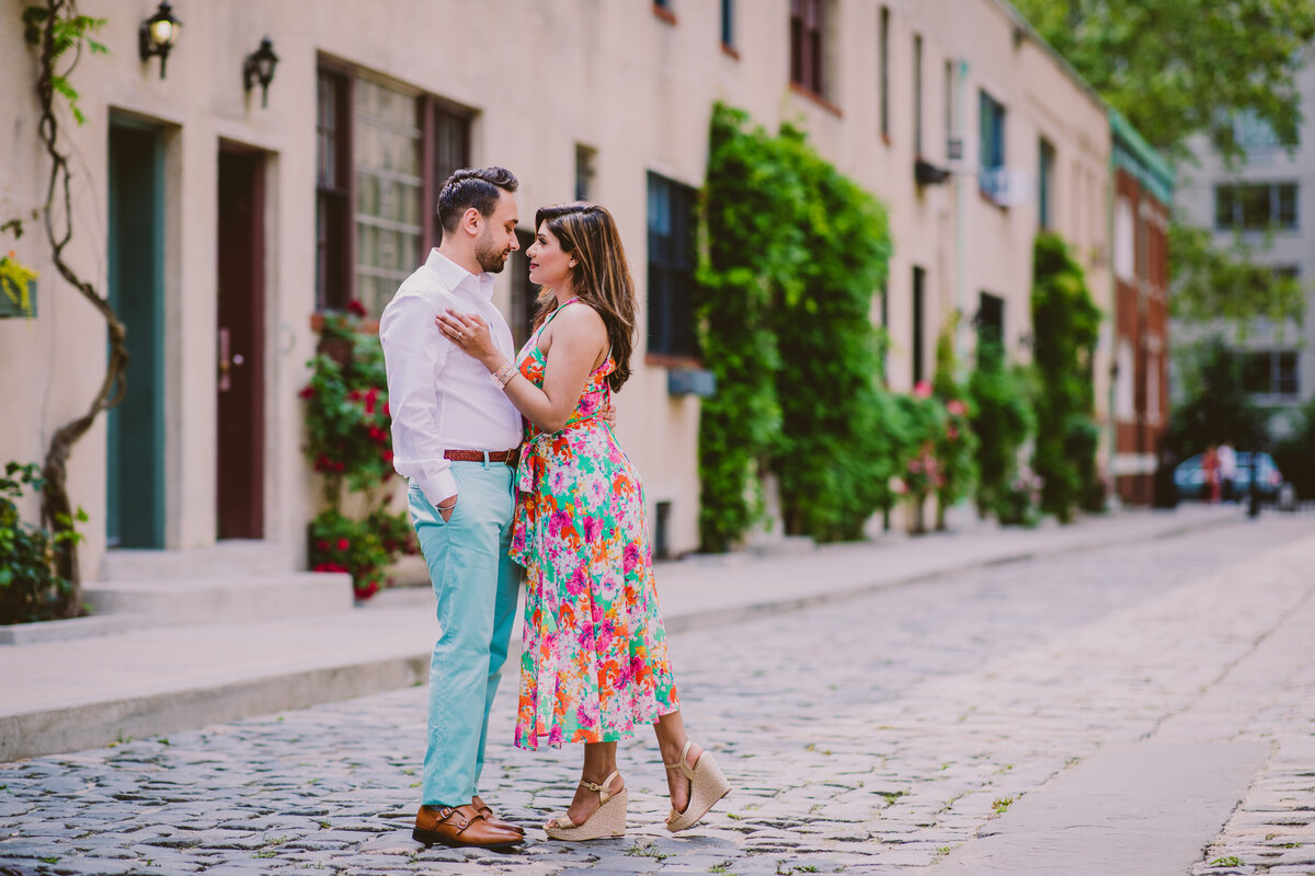 A couple looking at each other inside the washington mews cobblestone street in nyc
