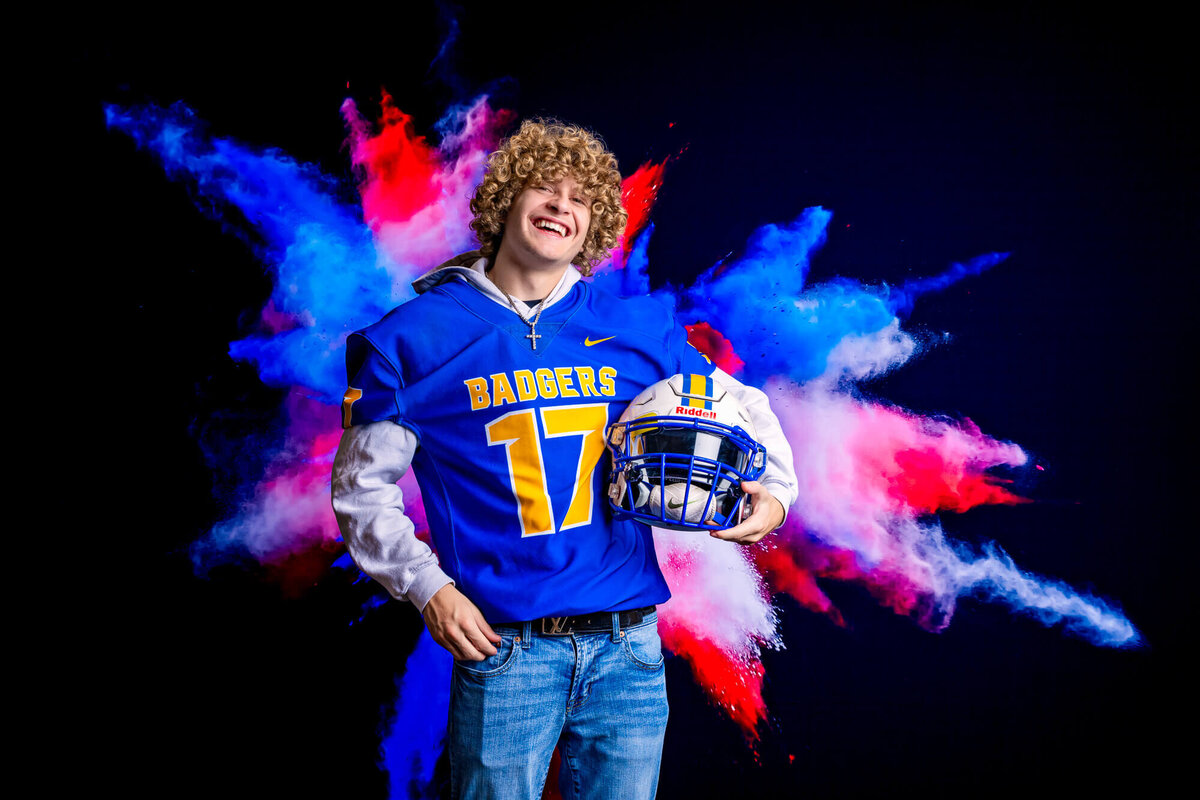 PHS football player poses with helmet in Prescott senior photography session with Melissa Byrne