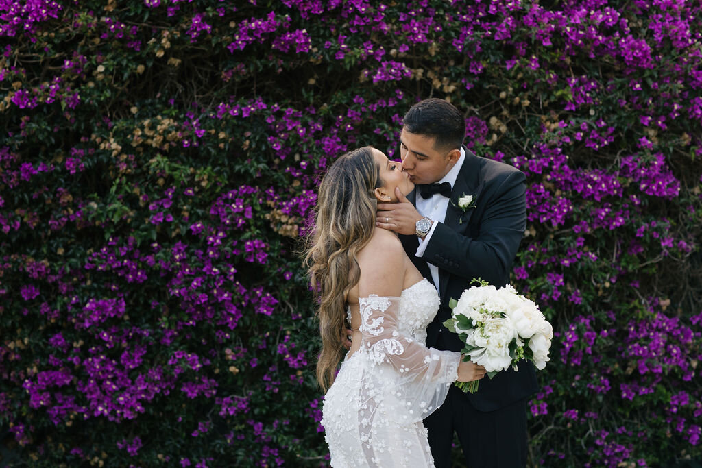 Couple kissing by the Bougainvillea wall