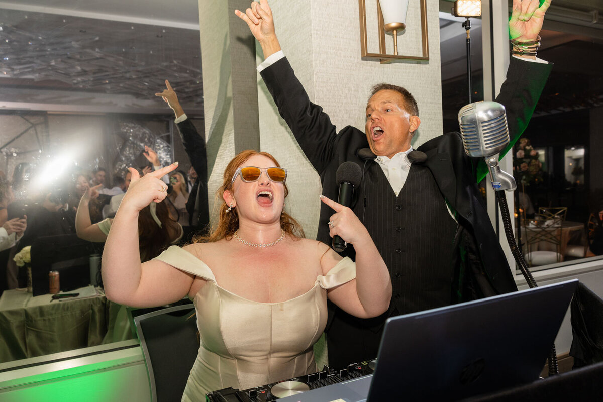 A man and a woman are singing into microphones at a party