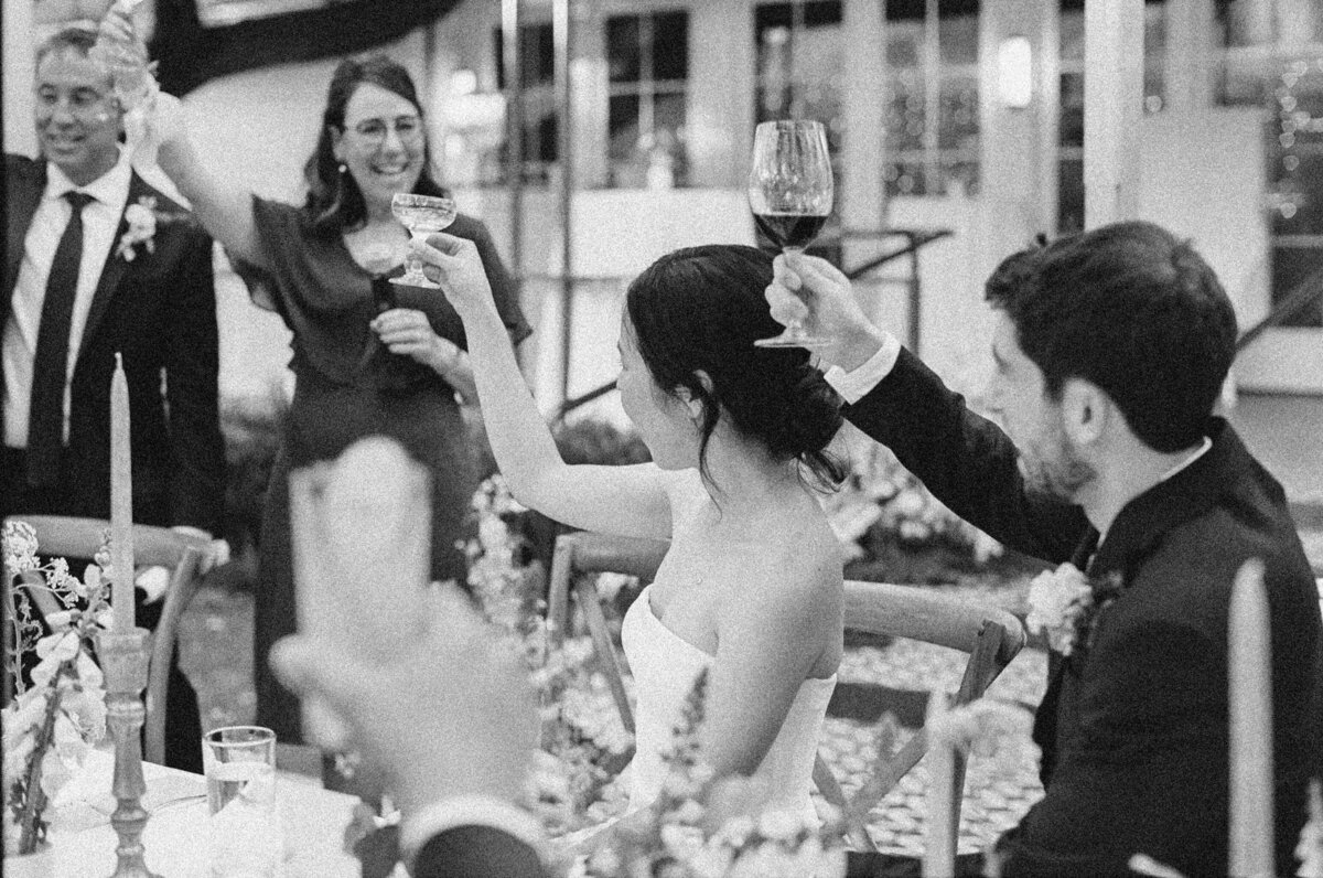 Bride and groom raising glasses at wedding reception in Austin