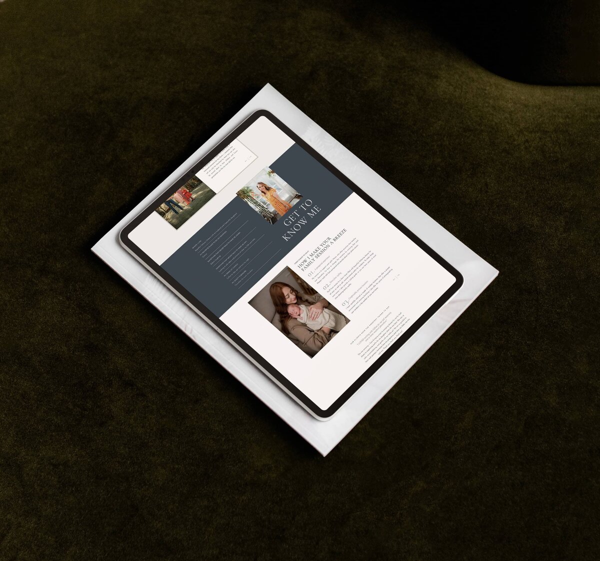 A tablet displaying a website with various articles and images is placed on top of a book with a white cover, both resting on a dark green surface. The website showcases brand and identity services for luxury photographers.