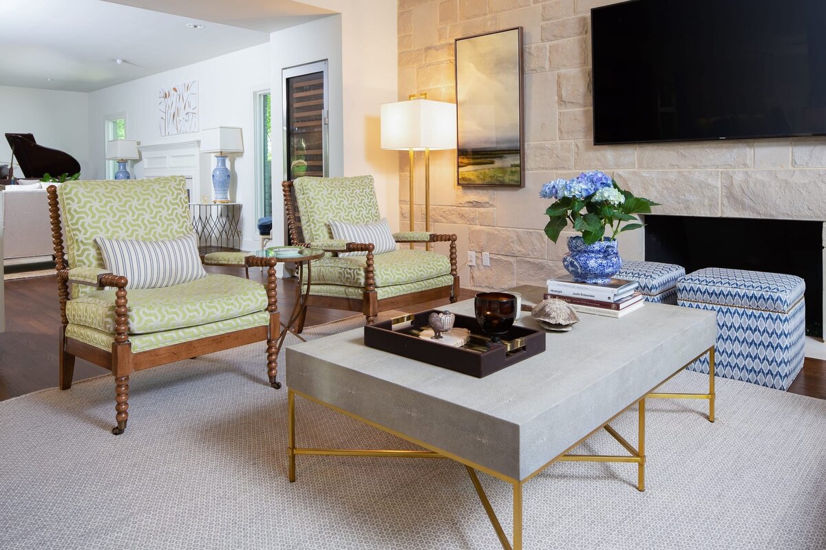 the keeping room interiors grant living room with green chairs and stone wall firplace and tv