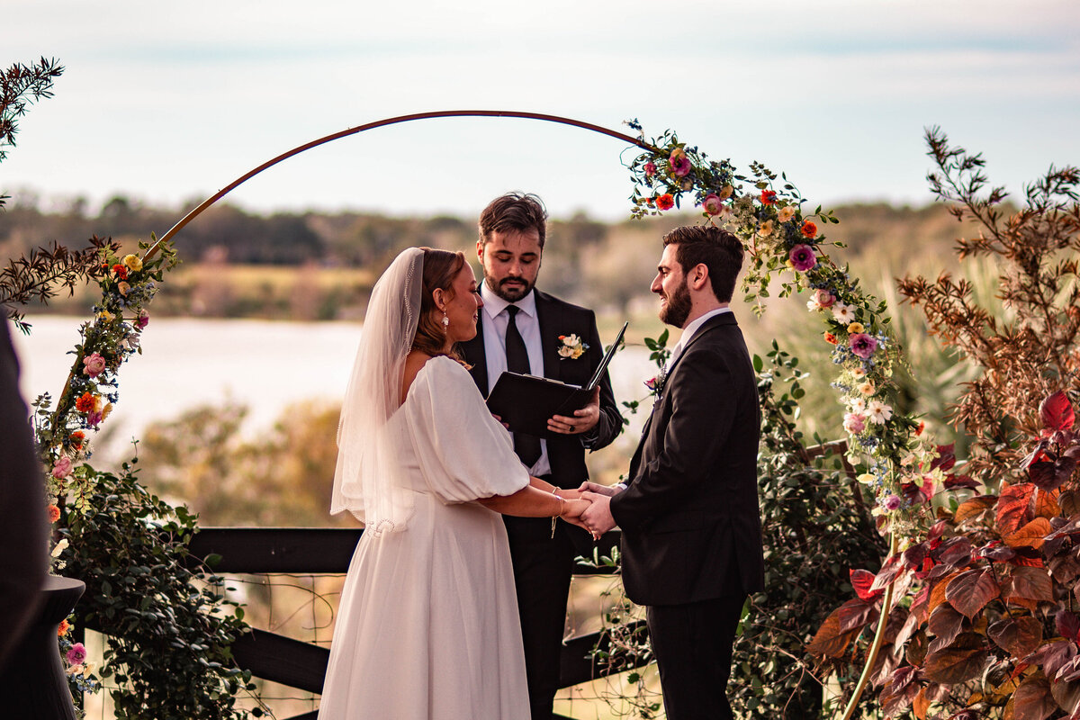 bride and groom reciting vows during a sunset outdoor ceremony