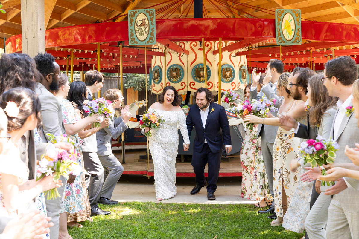 A bride and groom holding hands in between their wedding party