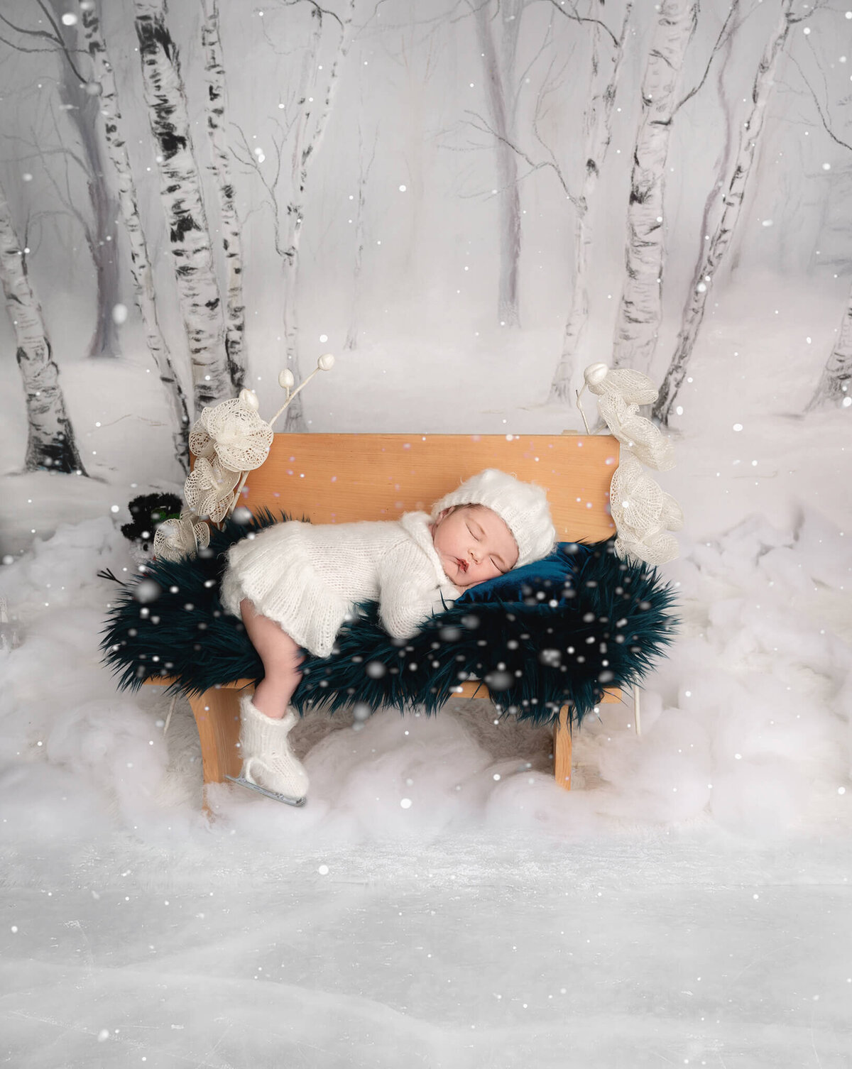 Infant baby girl sleeping on a bench at a winter scene skating rink by Tamara Danielle Photographer near Greater Toronto.