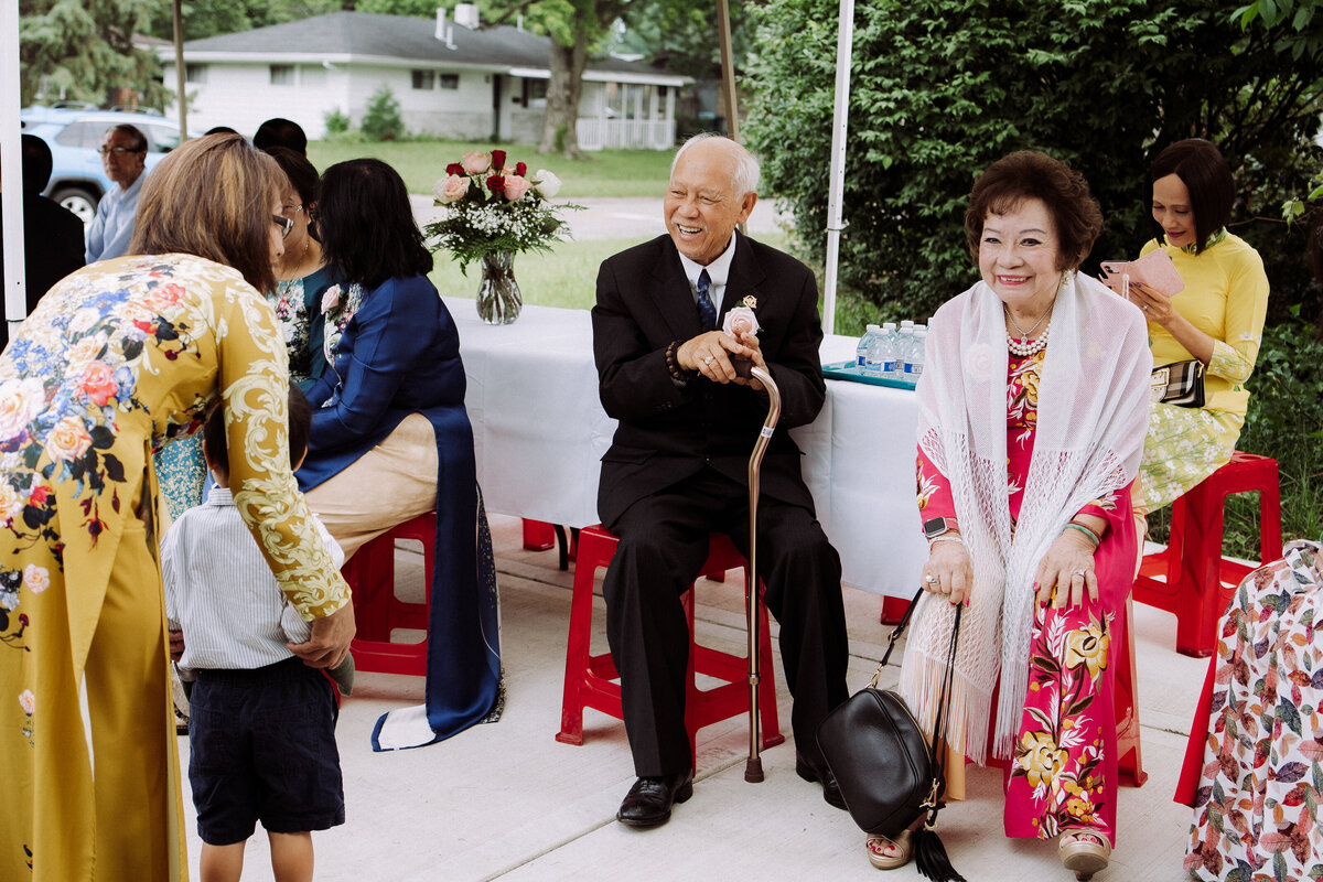 happy Asian guests sitting at wedding ceremony