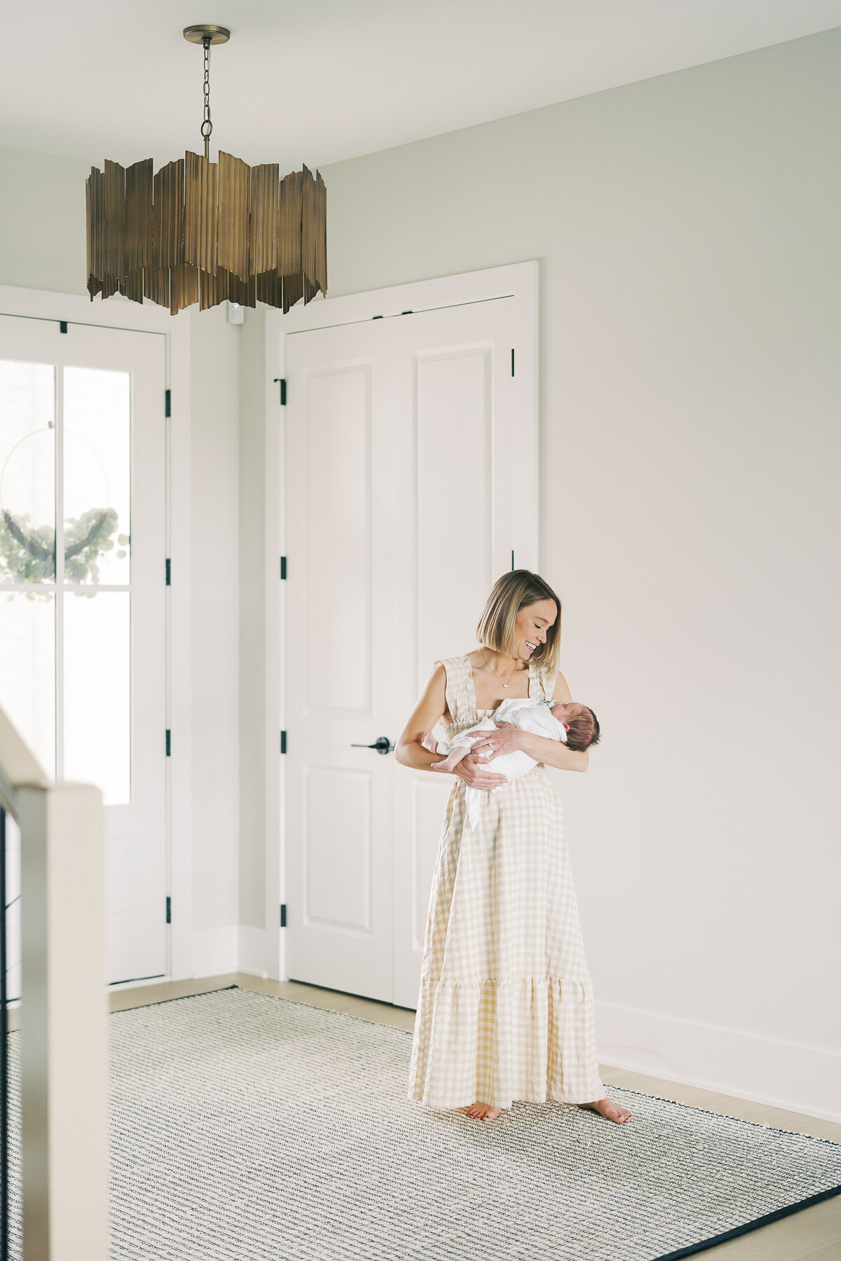 mom holding newborn baby in her home