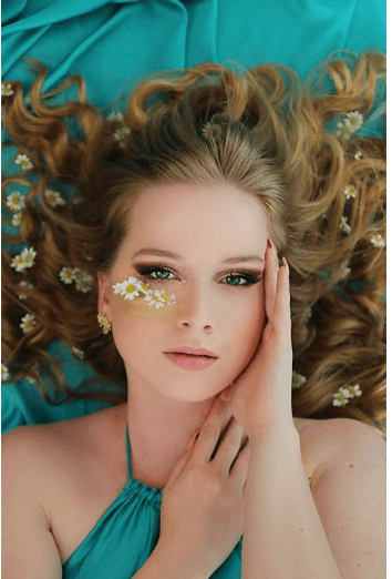 girl laying down on a blue dress with flowers on her chick