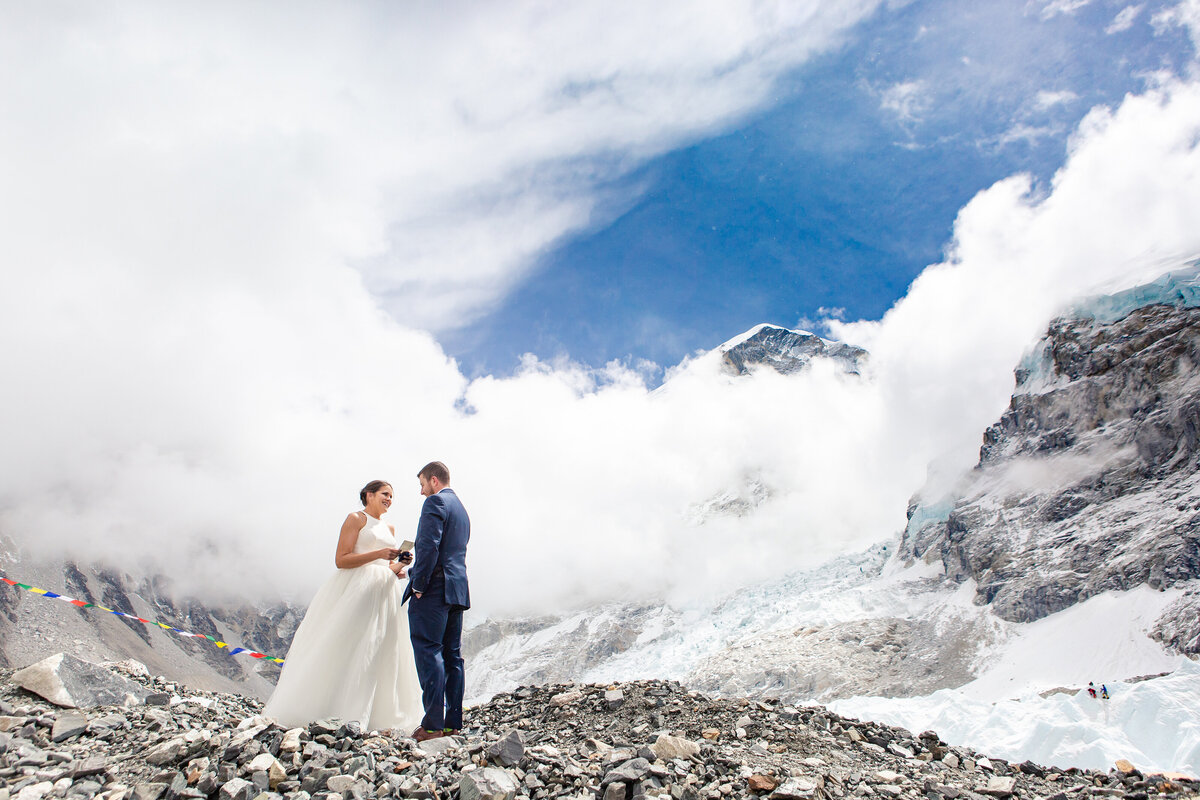 Dramatic elopement in Nepal at Mt Everest Base Camp, where the bride and groom exchange wedding vows in front of prayer flags and mountain peaks