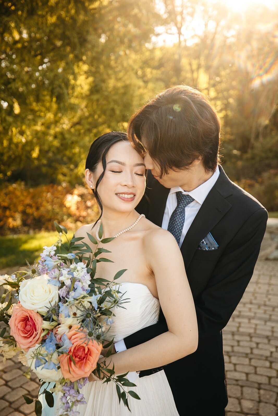 Bride smiling while groom hugging her in the back