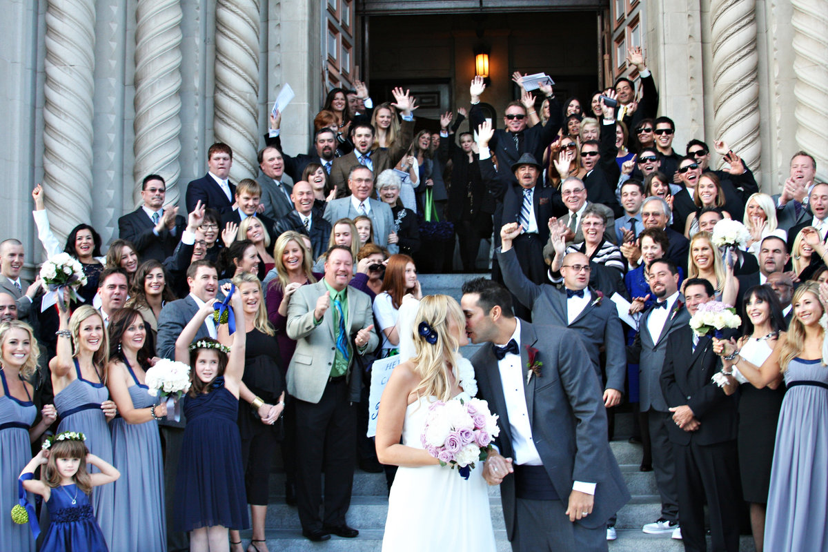 bride and groom on church steps with guests