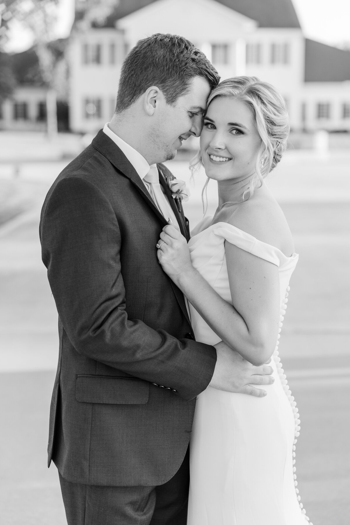 A timeless black and white wedding image of a bride and groom embracing with soft smiles and gentle connection. Captured in a classic and romantic photography style near Northlake, TX.
