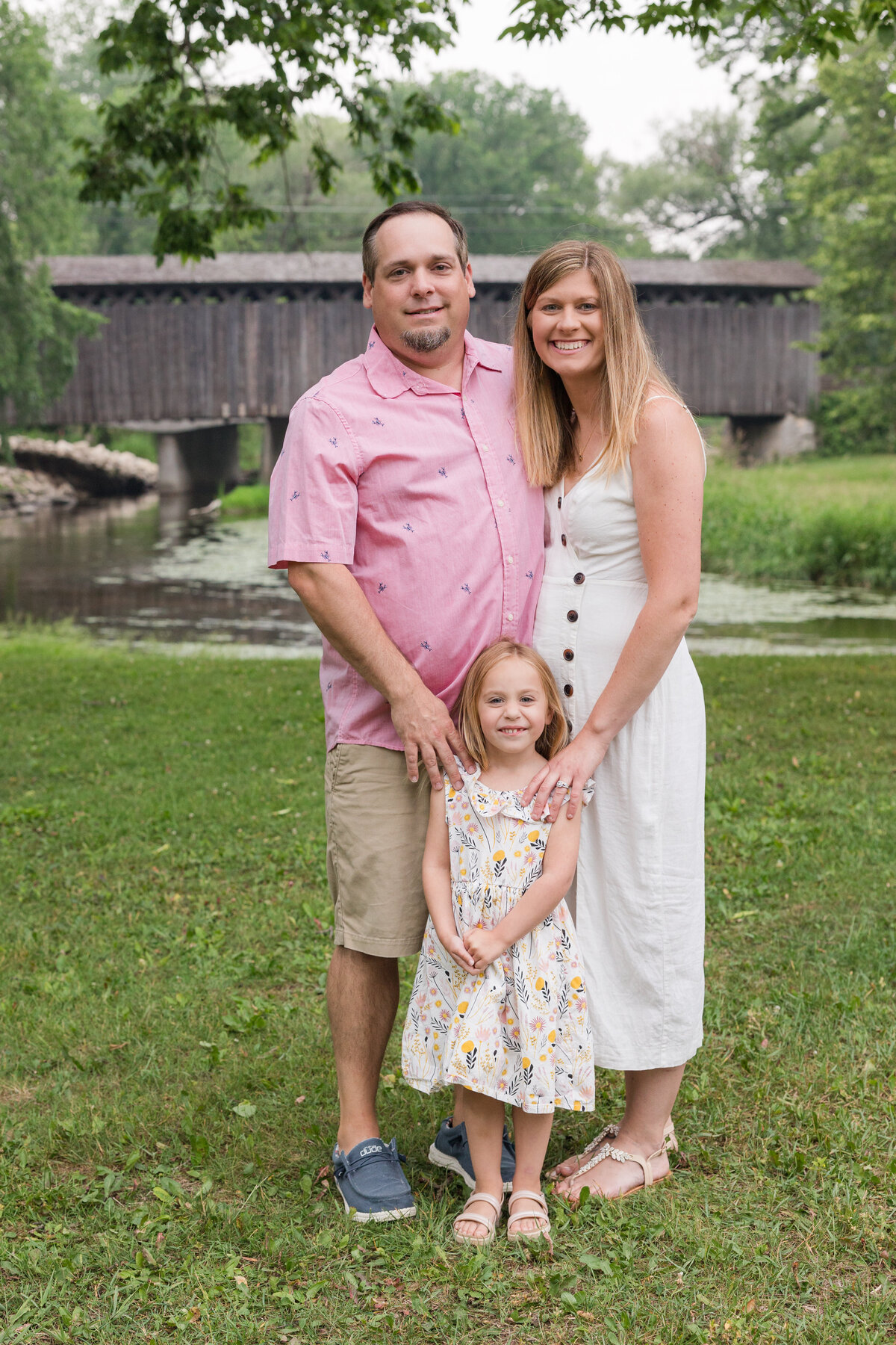 A family is standing in front of the camera together and smiling