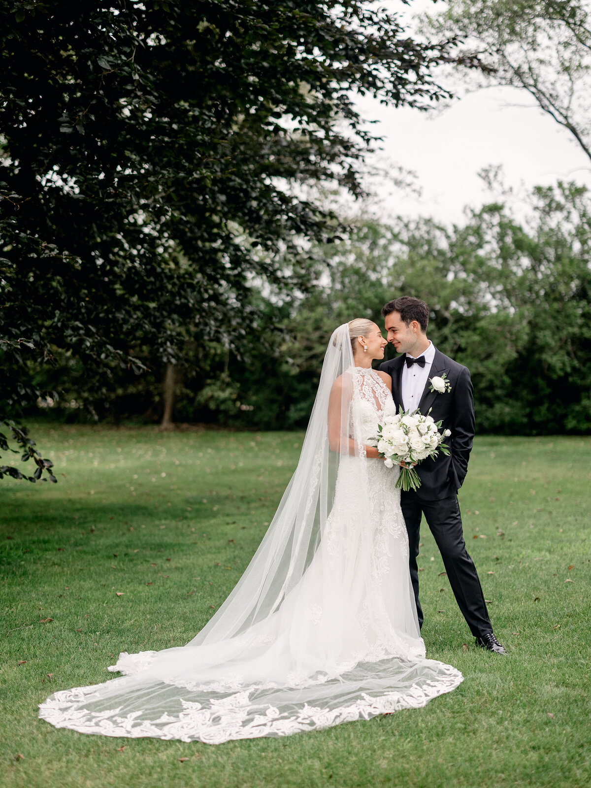 Bride and groom standing and smiling at each other before their Fine Art wedding at Rosecliff Mansion