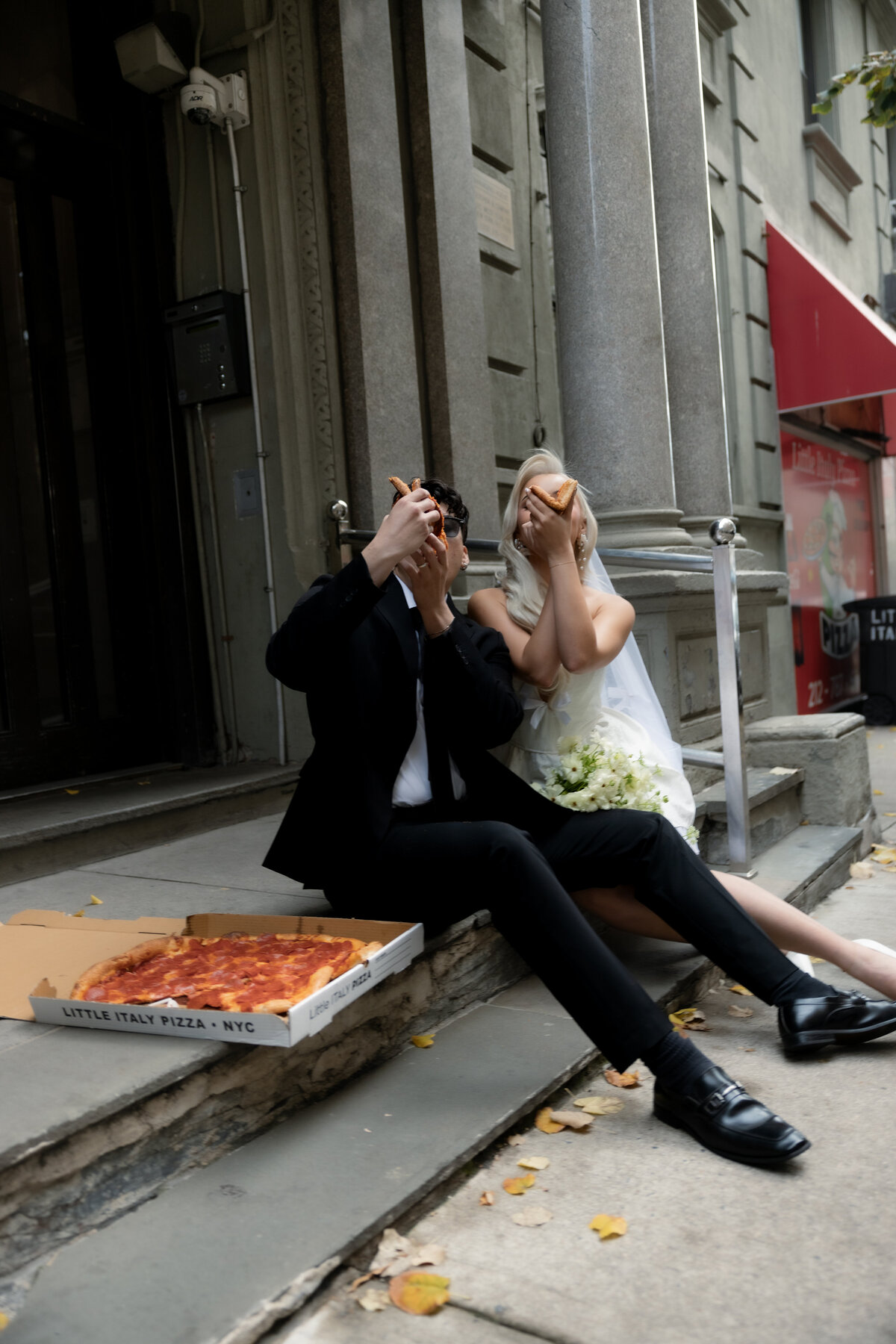 The couple having a playful pizza night in NYC to celebrate their intimate elopement.