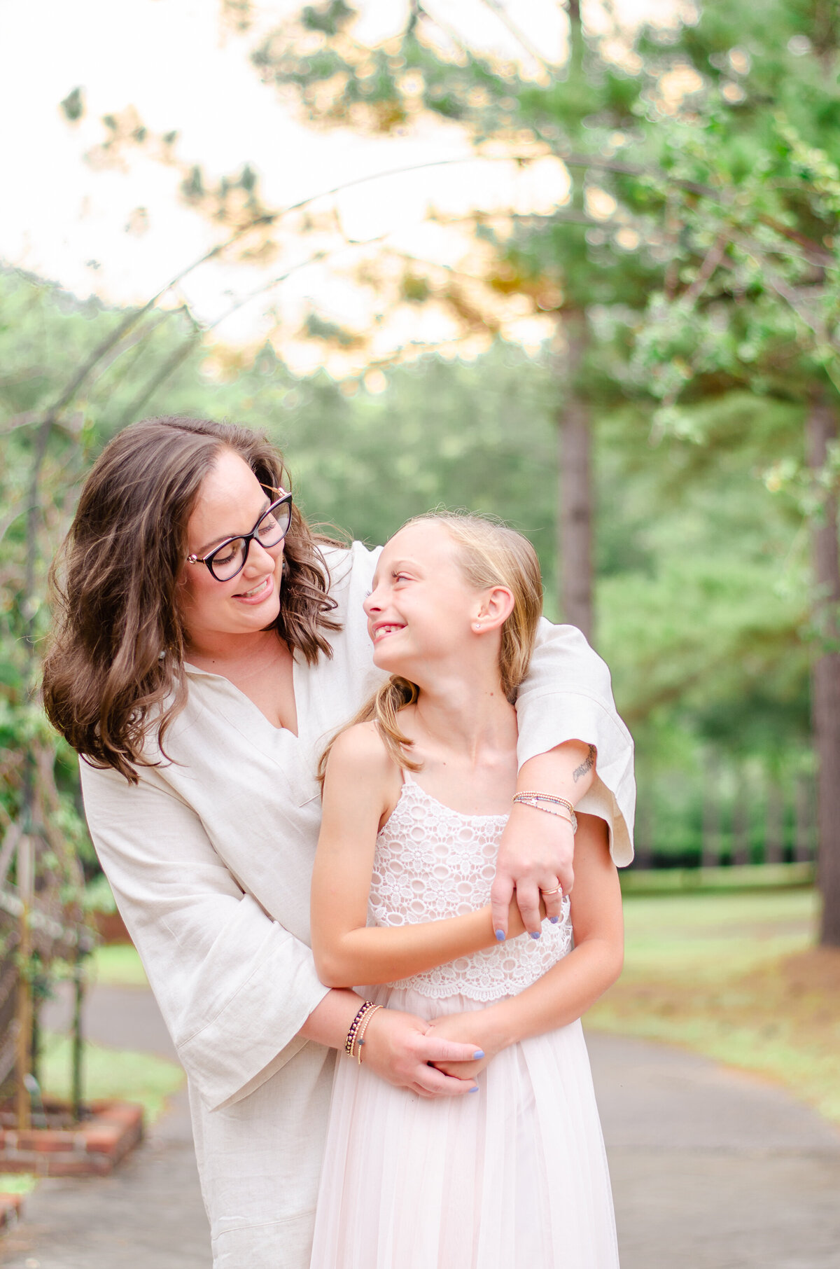 mother and daughter embrace in a rose garden