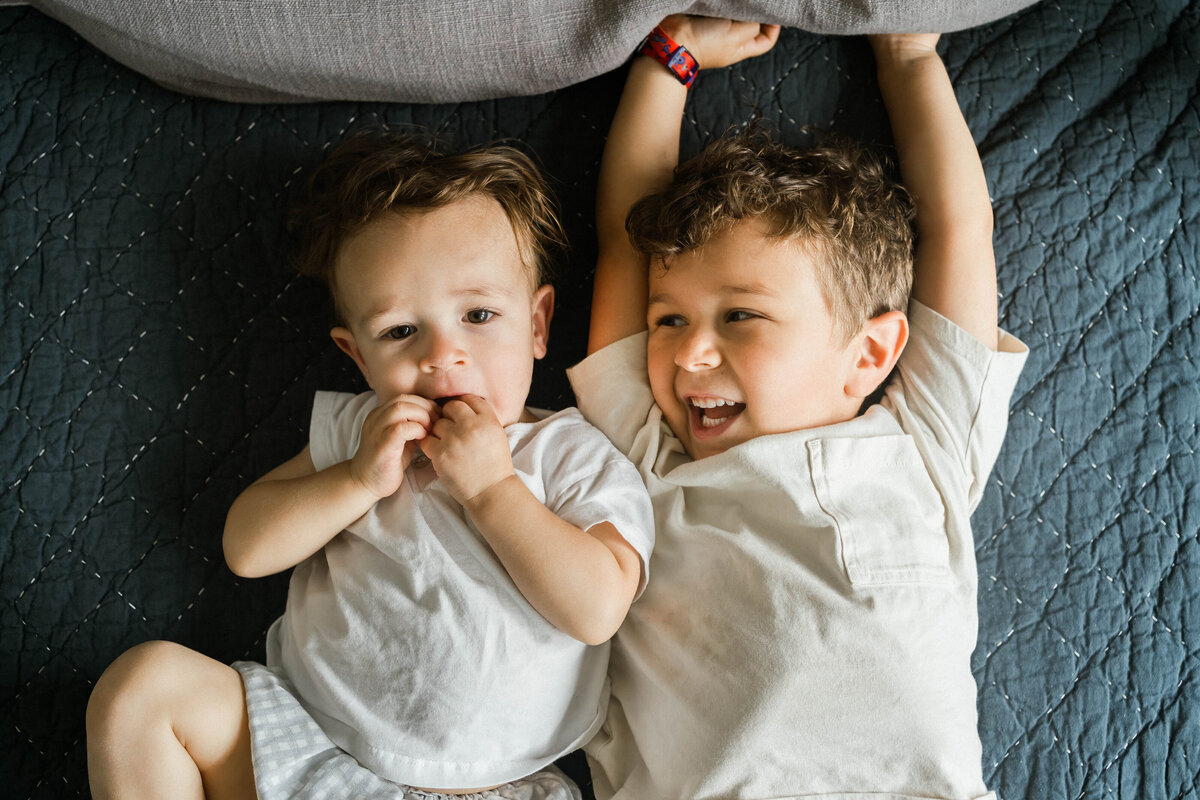 Brothers laying on a bed taken from above