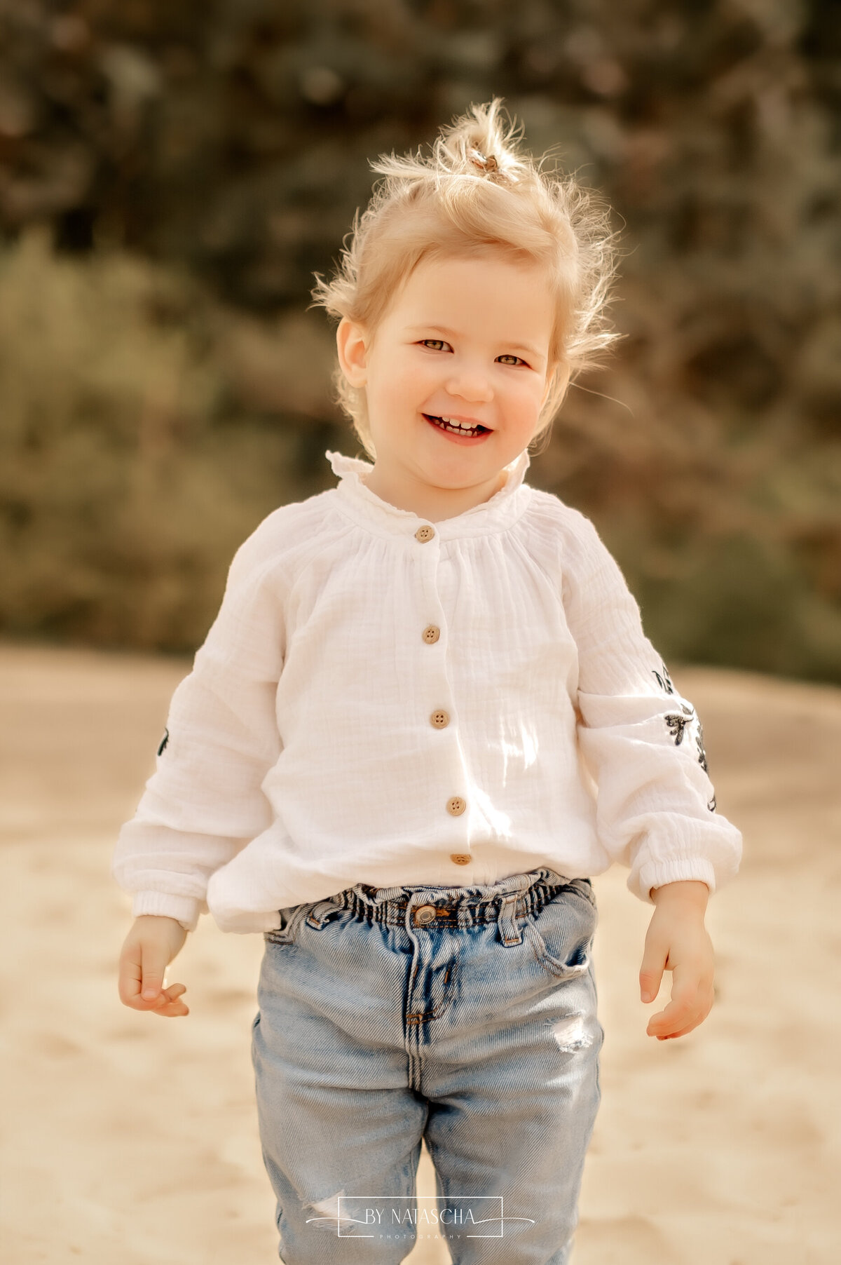 Lief meisje lachend naar de camera in duinen Herperduin
