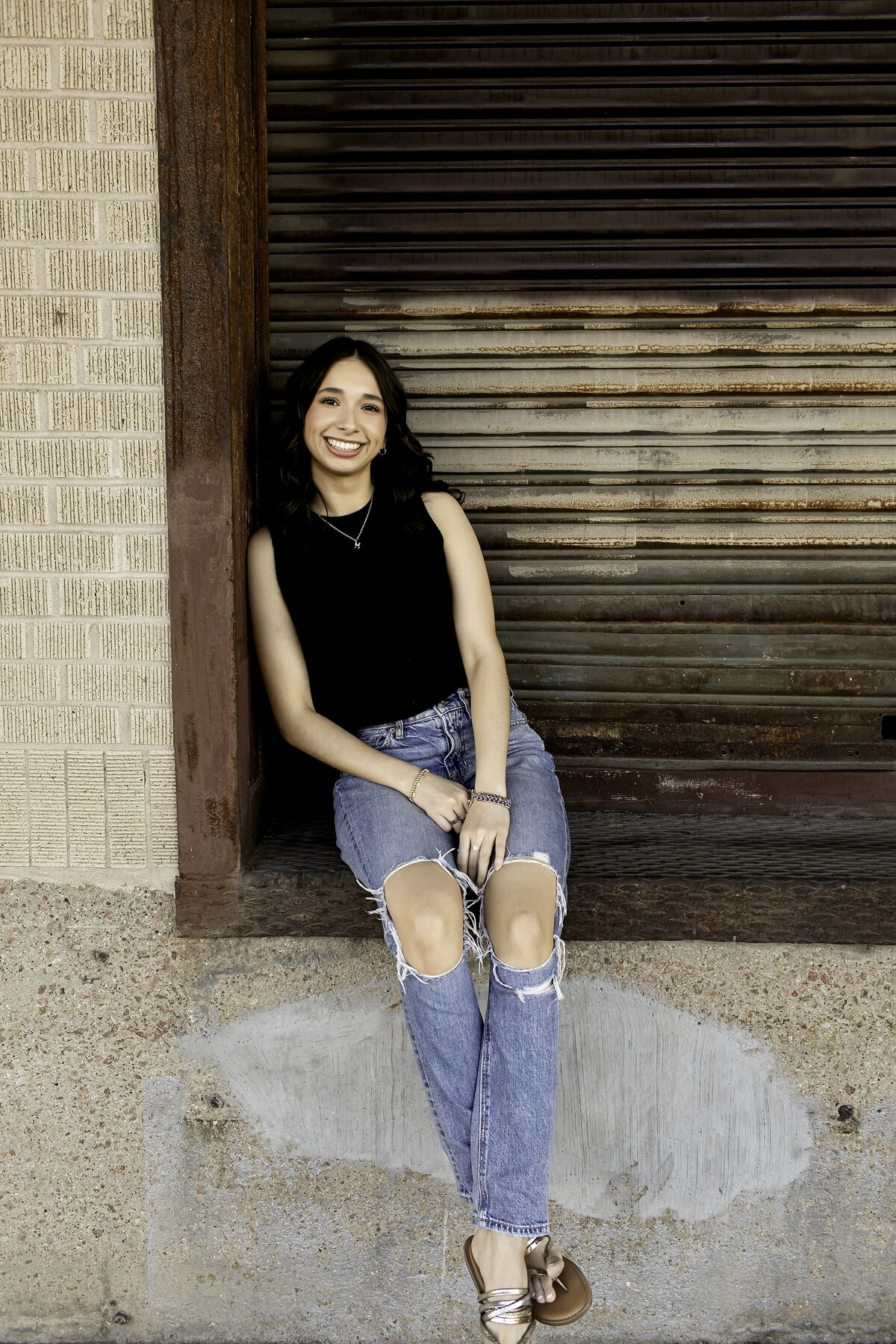 A high school senior confidently posing in front of vibrant street art at an urban location, capturing the perfect blend of city energy and personal style