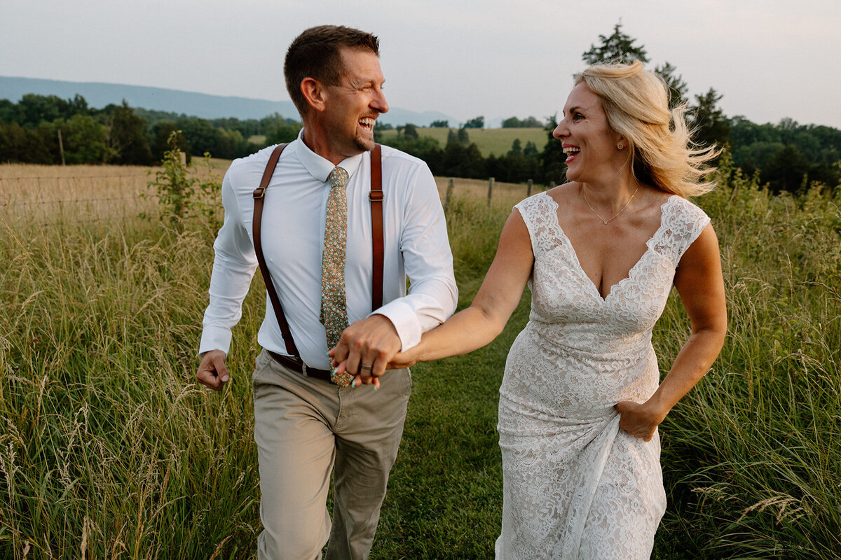 A bride and groom are running while holding hands during their elopement in Shenandoah