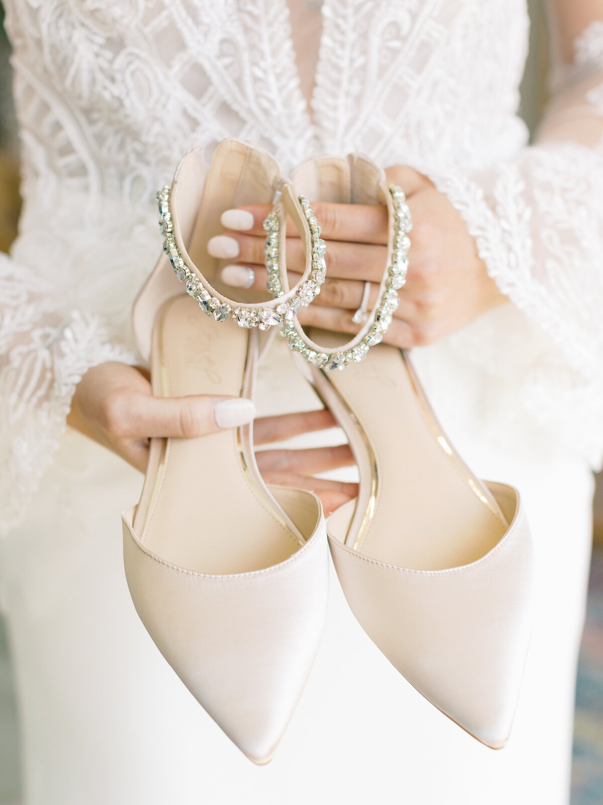 bride holding bridal shoes with jewels