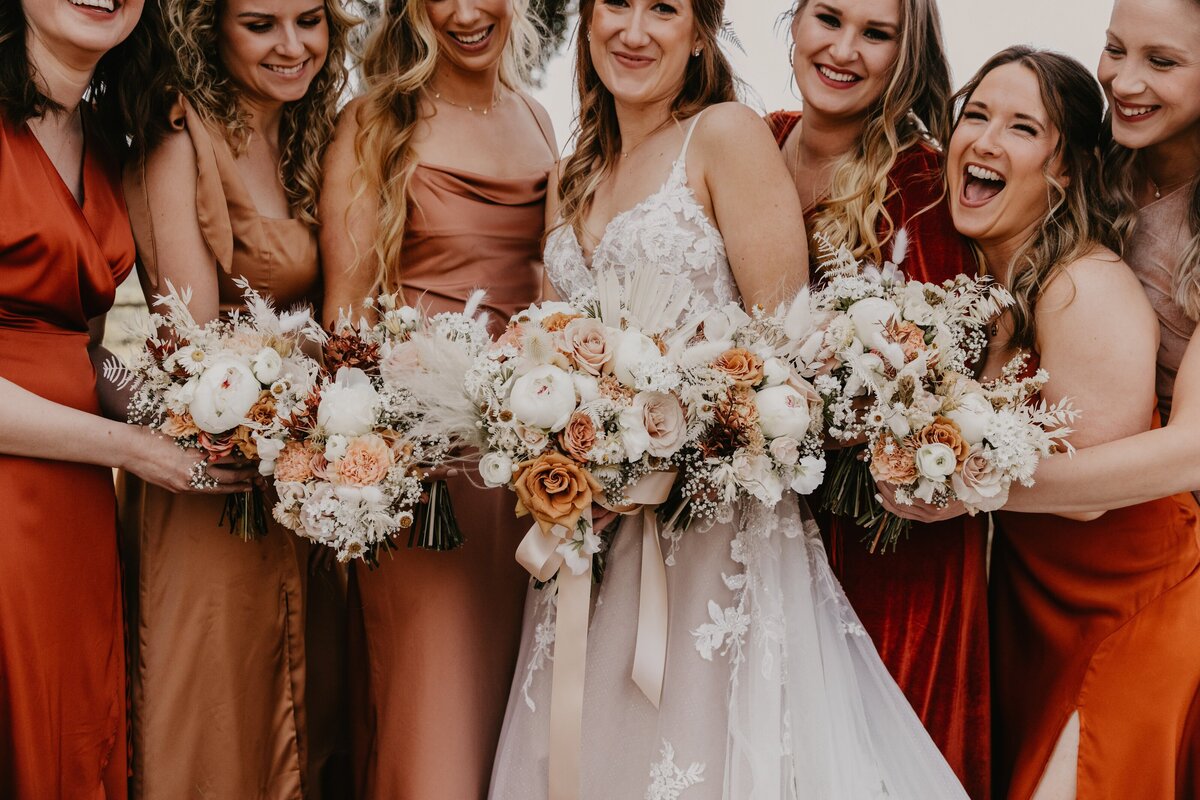 Bridal party smiling and holding their bouquets designed by Flowers and Thyme.