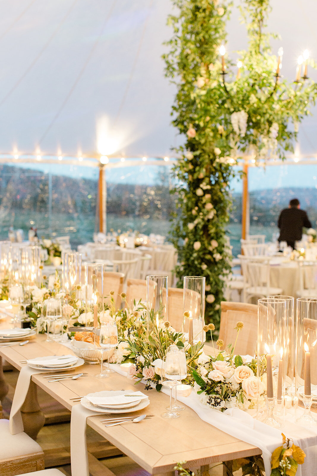 elegant wedding reception with floral centerpieces, glassed candles and dinnerwares