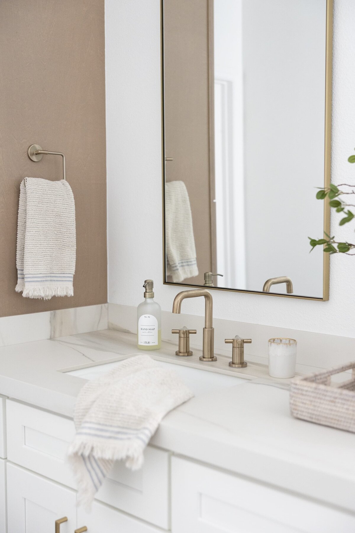 dewine design orlando interior designer contemporary coastal primary bathroom gold framed mirror and white countertop