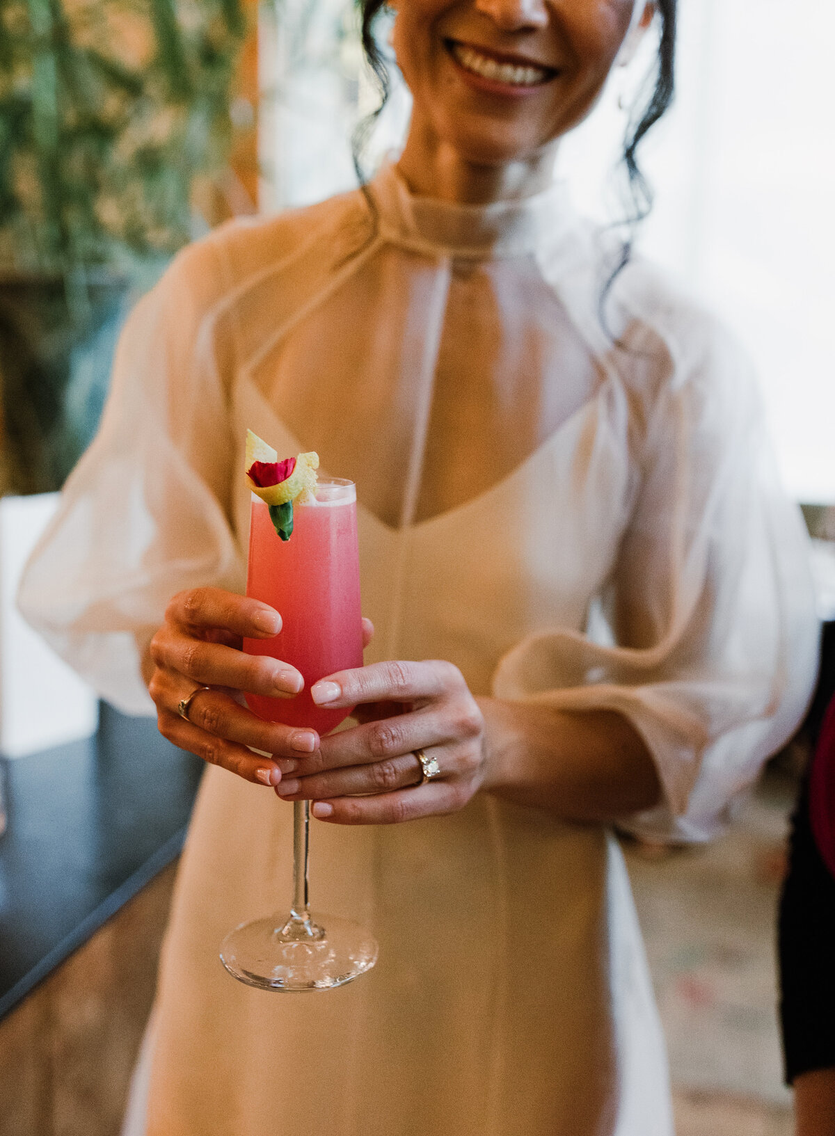 Bride holding pink cocktail at cocktail hour at Proper hotel Austin