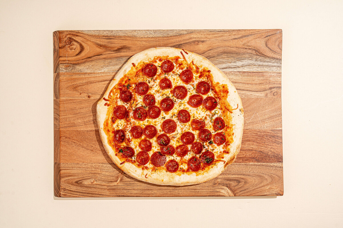 Food product photography in Columbia, SC featuring pepperoni pizza on an ivory background