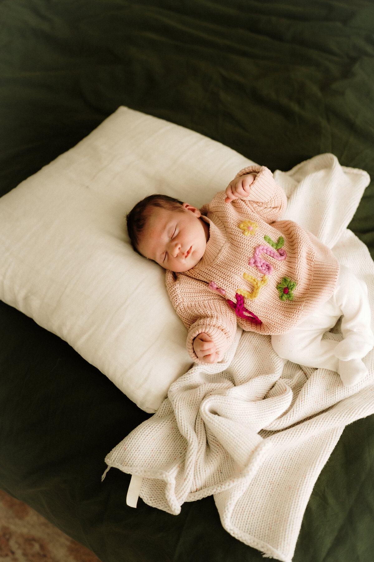 Sleepy newborn wrapped in a neutral blanket at home