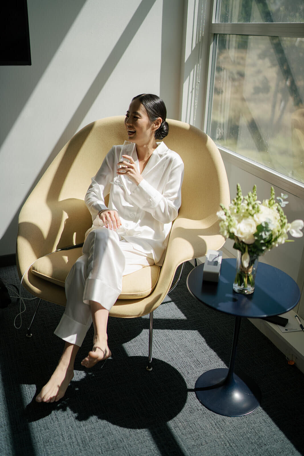 Bride enjoys a drink and a laugh with her friends while getting ready before the Aspen Meadows Resort Wedding.