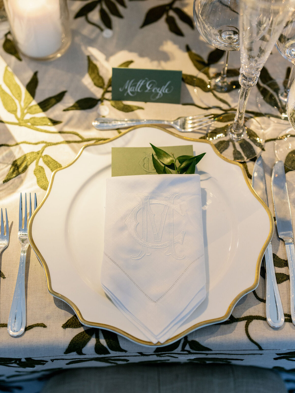 Close-up of the plate and embroidered napkins with the initials of the bride and groom.