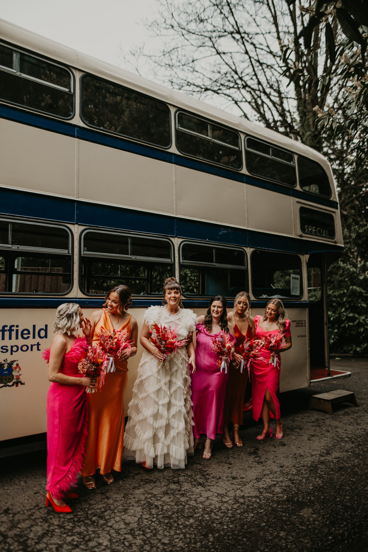 Bridesmaids and a bride wait outside a wedding bus in Sheffield.