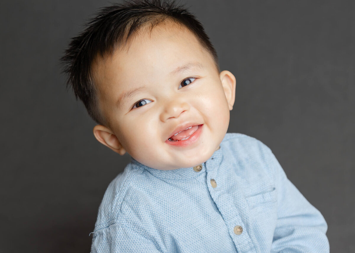 Daycare portrait of a cute Asian toddler boy laughing in a school portrait by las vegas school photographer