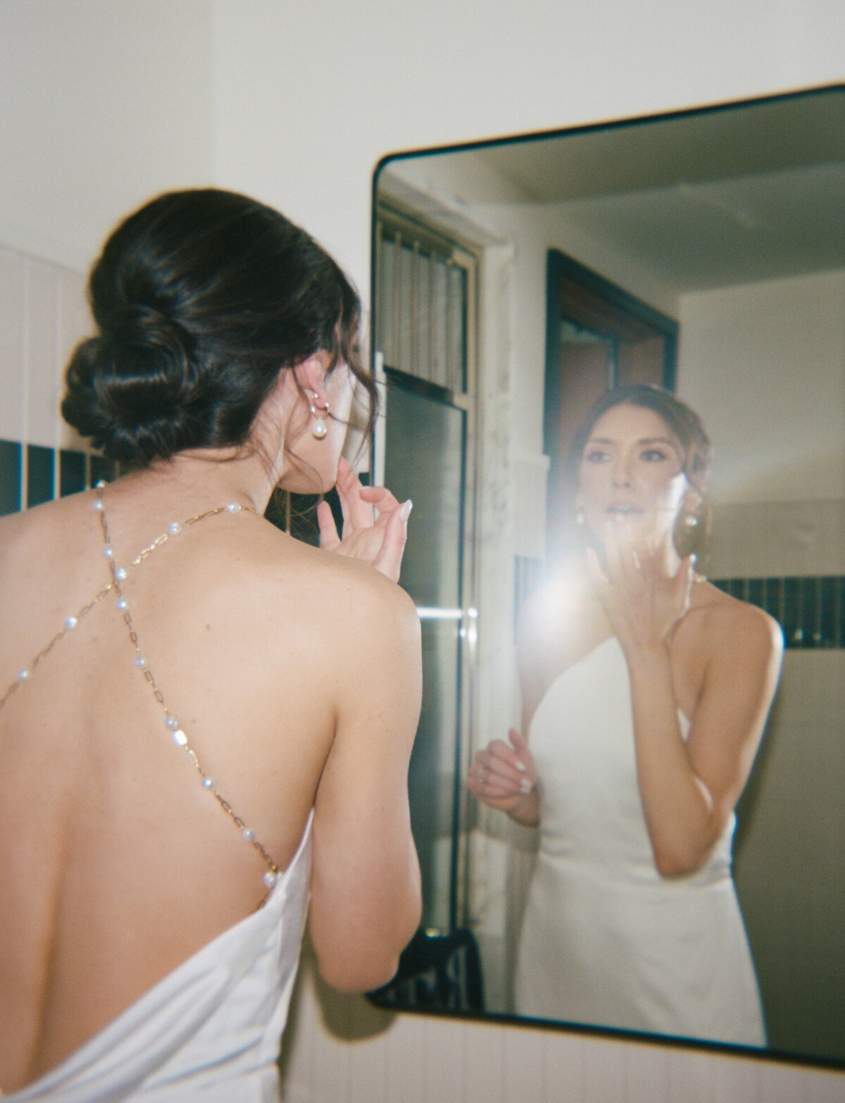 film wedding photographer in Detroit captures bride with open back dress, pearl back wedding dress, lip gloss in mirror