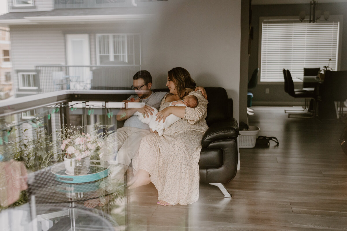 Family Holding Baby On Couch