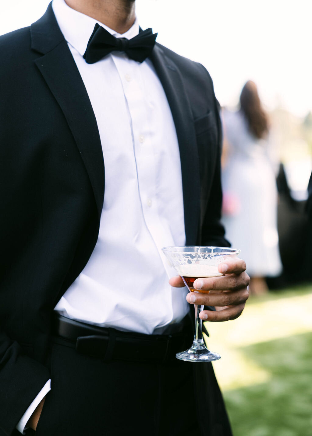Wedding guest in tuxedo holding a cocktail during Arizona Biltmore cocktail hour.