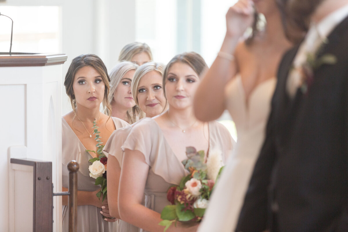 A bridesmaid watches as the wedding ceremony officiant speaks.